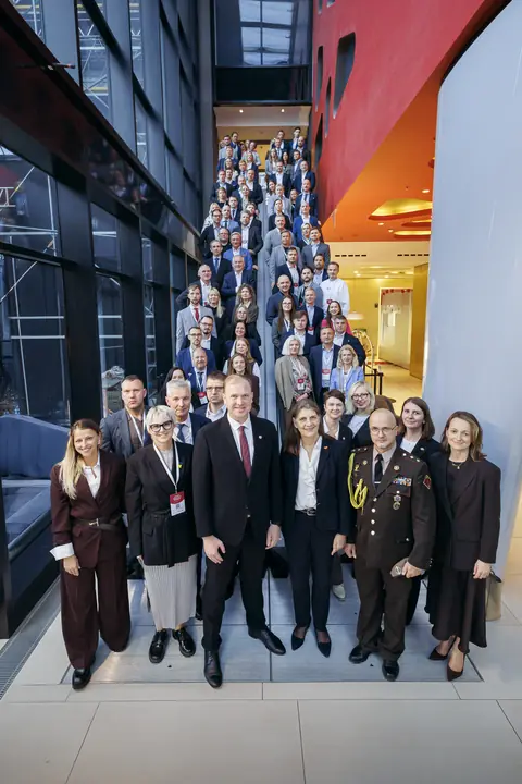The full trade mission delegation on a staircase at the opening event in Berlin.