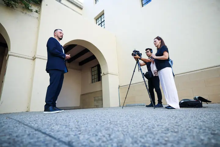 Aleksandrs Gusevs of Double Helix Technologies being interviewed on camera in a Caltech courtyard.